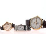 trois types de montres différents posés sur une surface blanche, sur fond blanc