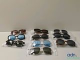 Plusieurs paires de lunettes de soleil sont posées les unes à côté des autres sur une table.