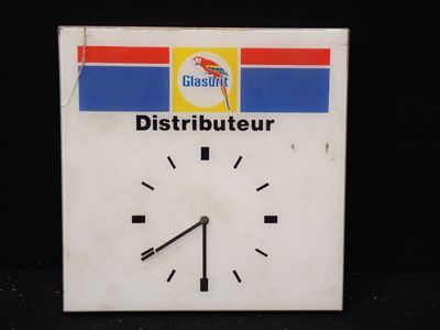 une horloge blanche ornée d'une bande bleue, rouge et jaune