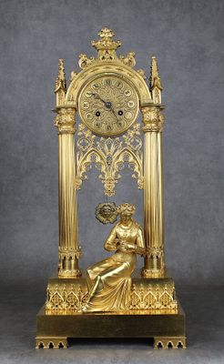 une horloge en or sur laquelle est assise une femme