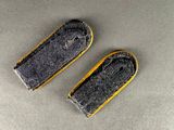 pair of black and yellow leather luggage tags on a gray surface