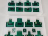 quelques morceaux de circuit imprimé vert posés sur une surface blanche