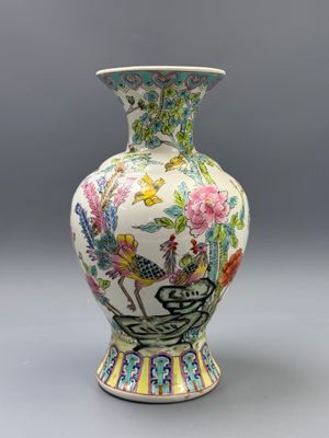 un vase orné d'un oiseau et de fleurs