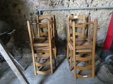 quatre chaises en bois placées les unes à côté des autres dans une pièce