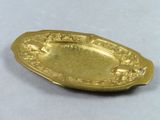 gold plate with a design of flowers and leaves on it