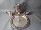 a silver plate with a silver tea pot and a silver plate with a silver tea pot and a silver plate with a silver tea pot and a silver plate