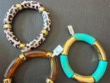 trois bracelets à imprimé léopard et détails dorés sur une base en cuir noir