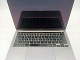 a silver laptop with a black keyboard on a white table