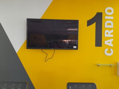 un téléviseur fixé au mur dans une salle de sport