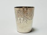 a silver cup with a floral design on it