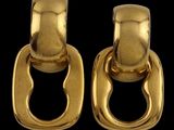 une paire de boucles d'oreilles en or avec des maillons ovales sur fond noir