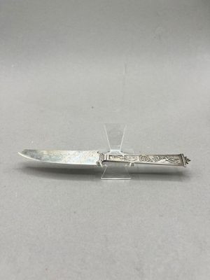 an antique silver plated knife sitting on top of a table
