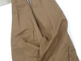 brown pants on a white surface with a pair of scissors in it