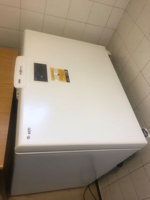 un réfrigérateur blanc dans un coin d'une petite pièce
