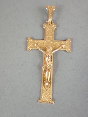 crucifix plaqué or représentant Jésus sur la croix, sur fond gris