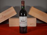 a bottle of wine sitting on a table next to two wooden boxes