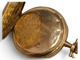 a gold pocket watch that is open on a white surface