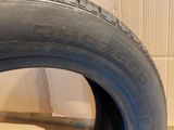 a close up of a tire on a wooden floor next to a wall