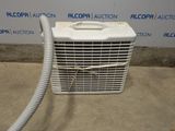 an air conditioner sitting in front of a wall with a hose attached to it