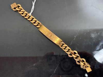 gold plated bracelet on display in glass case with black background