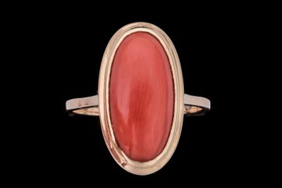 Gros plan sur une bague contenant une pierre rouge