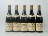 six bouteilles de vin sont alignées sur une surface blanche