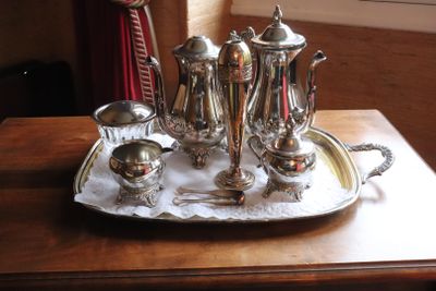 a silver tray with a silver tea set on it