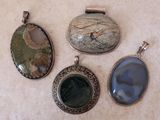 trois pendentifs de formes et de tailles différentes sur une surface blanche