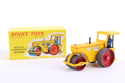 yellow and red toy tractor and box of dinky toys