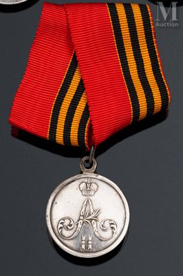 une vieille médaille entourée d'un ruban, posée sur une surface noire