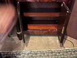 a person standing in front of a cabinet with a rug on the floor