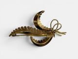 a gold brooch with a bird on it