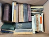 a cardboard box filled with old books on top of a table
