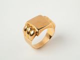 gros plan d'une bague en or sur une surface blanche