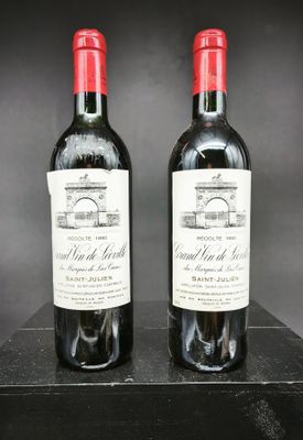 deux bouteilles de vin rouge posées sur une table en bois