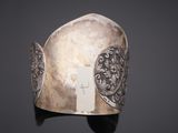 silver cuff bracelet with an intricate design on a black background