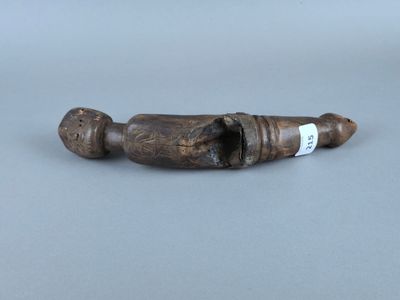 une vieille pipe en bois, avec une étiquette, posée sur une table