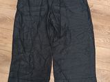 Le short est noir et comporte une fermeture éclair sur le côté.