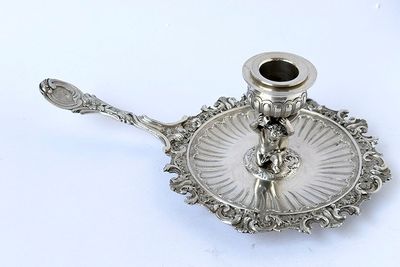 a silver plate with a candle holder on top of it