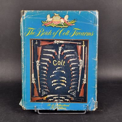 an old book with a picture of guns on it on a black background