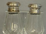 two salt and pepper shakers sitting on a clear tray