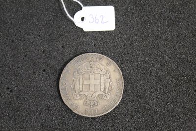 une pièce d'argent posée sur une surface noire, sur laquelle est apposée une étiquette de prix