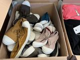 plusieurs paires de chaussures dans une boîte posée sur le sol