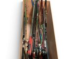 many fishing rods in a wooden box on a white surface