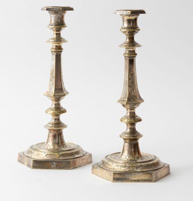 pair of antique brass candlesticks on a white background