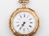 une montre de poche en or avec des chiffres romains sur le cadran