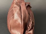 a close up of a brown leather bag with a metal handle