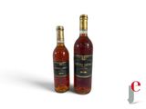 two bottles of wine sitting next to each other on a white surface