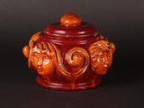 an image of a red jar with carvings on it