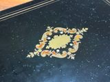a picture of a black table with a gold design on it